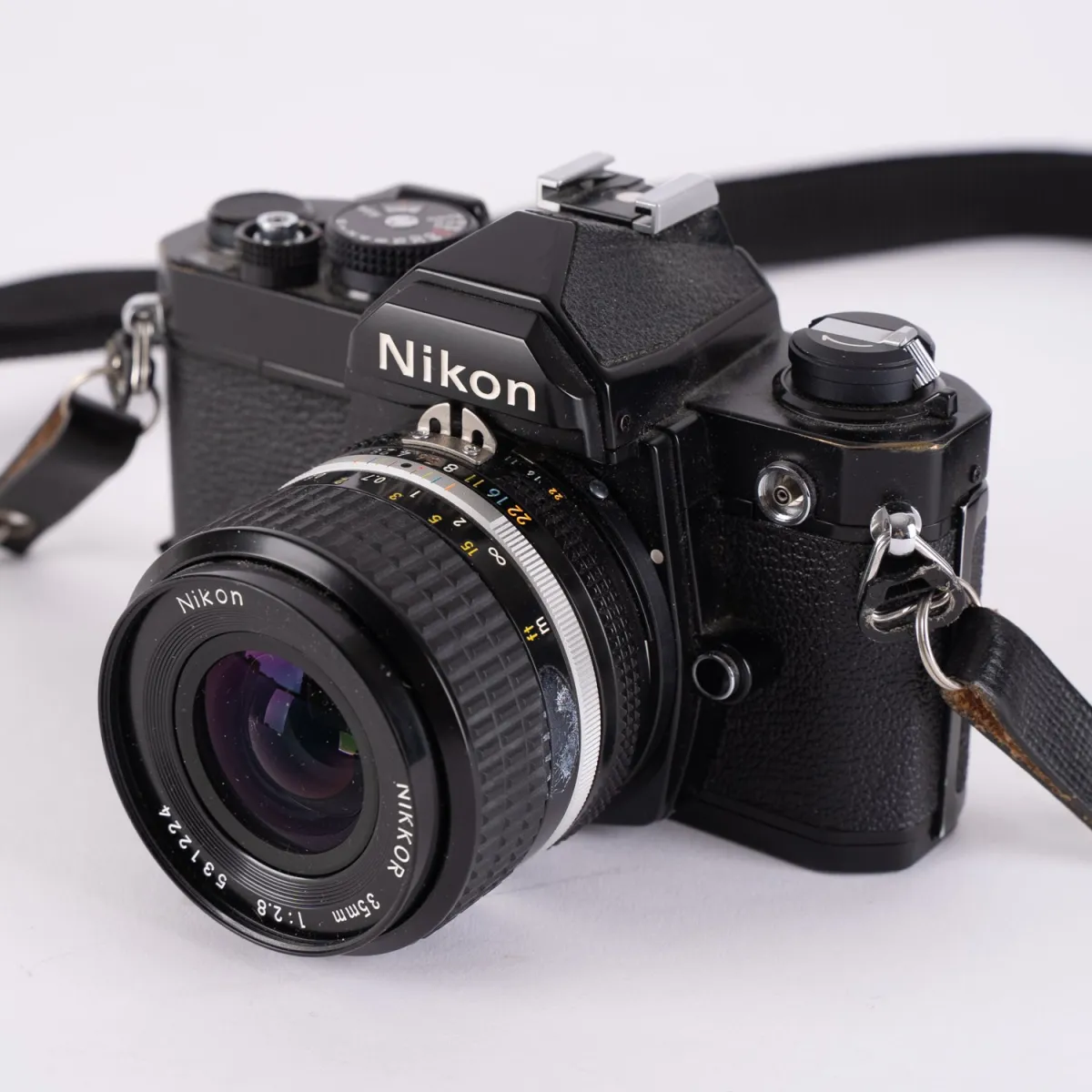 Appareil photo reflex analogique Nikon FM, avec objectifs Nikkor 35 et 85 mm, optique claire, non testé. Dans un étui en aluminium adapté