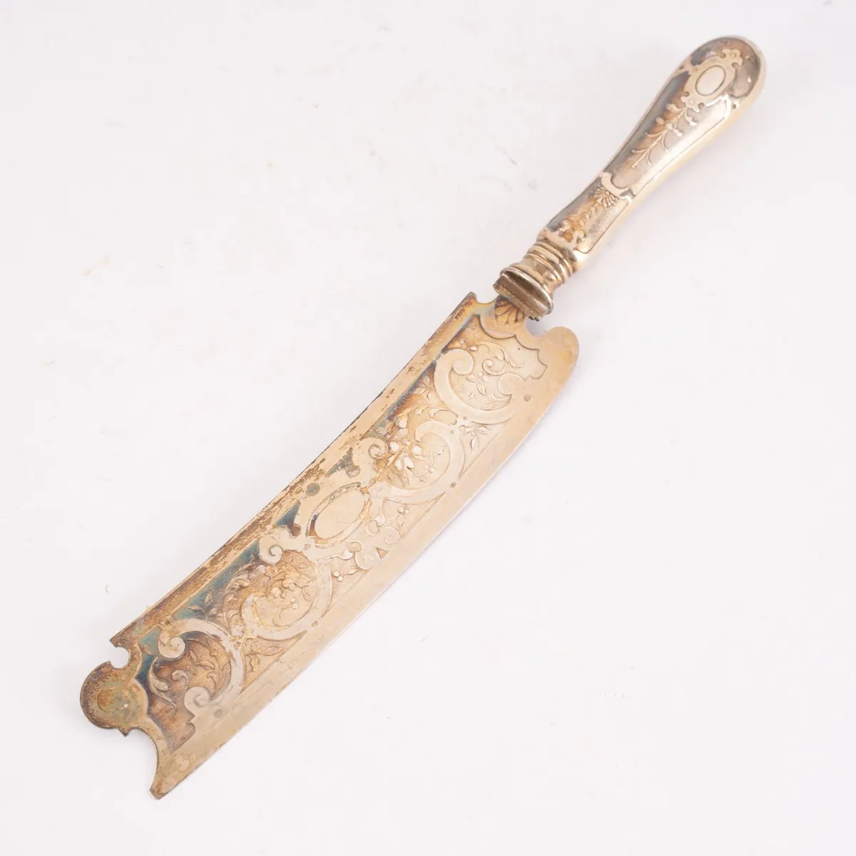1 cheese knife, silver-plated or gold-plated, richly chased on the front, length approx. 27.5 cm, width max. approx. 4 cm…