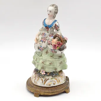"Femme au panier de fleurs", décoration de table française en porcelaine, polychrome avec peinture à l'or, montée sur socle en bronze, vers 1850.
