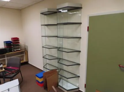 1 partij kantoormeubilair bestaande uit 4 x werktafels, houten blad met metalen frame, 7 x bijzetstoelen, stoffen bekleding, 1 x rolcontainer, 4 laden, 1 x Akenside sideboard met dubbele schuifdeur, 2 x glazen vitrines, hoogte 2,20 m, elk 6 niveaus