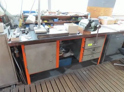 1 pracovní stůl, cca 180 x 90 cm, se 2 spodními skříňkami, 3 zásuvkami, 1 křídlovými dveřmi a namontovaným svěrákem