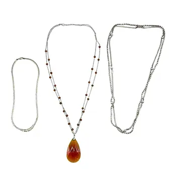 PARURE DE BIJOUX COMPOSÉE DE DEUX CHAÎNES DOUBLES ET D'UNE CHAÎNE À MAILLONS.