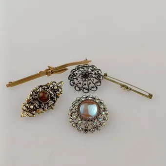 LOT VAN 5 BROCHES, sieraden, 20e eeuw, verschillende uitvoeringen in zilver- en goudkleurig metaal