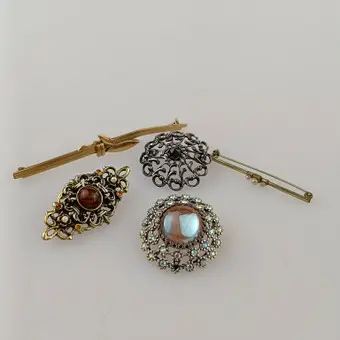 KONVOLUT 5 BROSCHEN, Modeschmuck, 20. Jh., unterschiedliche Ausführungen in silber- und goldfarbenem Metall.