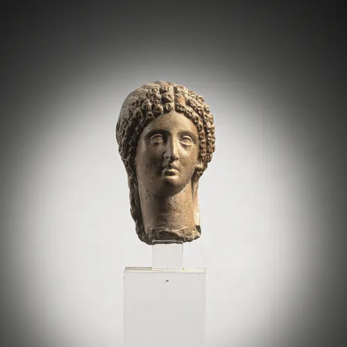 Head of a woman in reddish clay