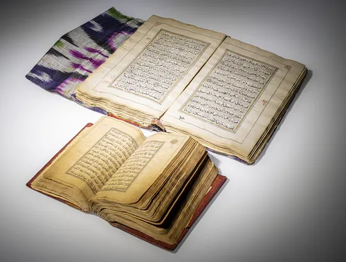 Two Qurans, one in leather binding, the second with ikat binding