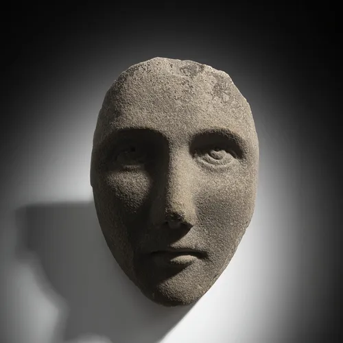 Mask-like facial relief in stone