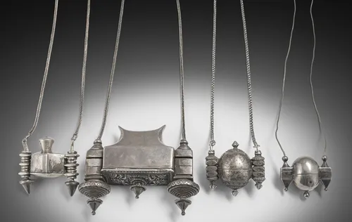 Group of four Shiva Lingam containers with chains, mostly made of silver
