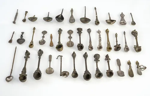 Grote groep lepels van metaal, deels van brons of zilver