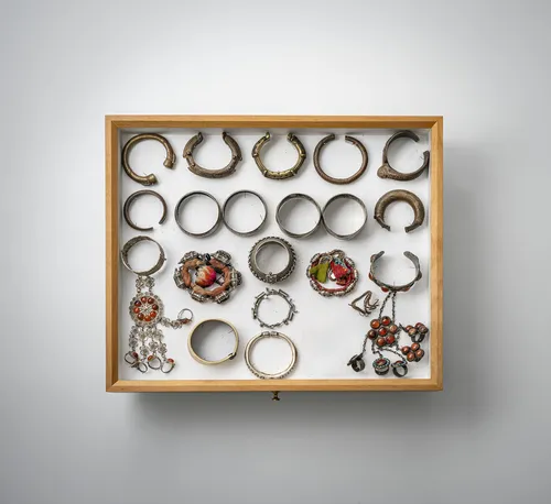 Group of bracelets, chains, pendants and amulet boxes, partly silver, mounted in two glass cases