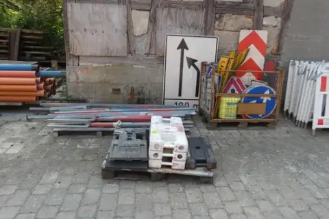 Sada dopravních značek a příslušenství, mimo jiné vodicí tabule, zábrany, základové desky a sloupky, částečně v mřížovém boxu