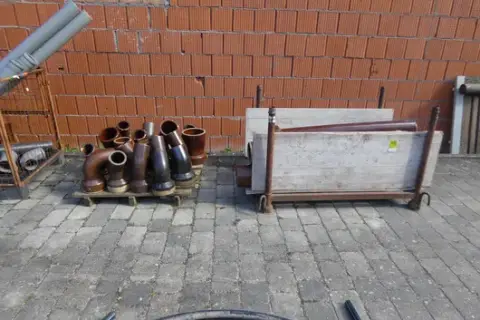 Stohovací regál a paleta s kameninovými trubkami a tvarovkami