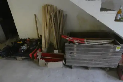 Lot of wooden handles, brooms, rakes and shovel blades