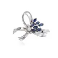 Witgouden broche in strikvorm met diamanten en saffieren.