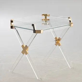 Acrylic table with gold metal fittings.