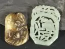 Pendentifs, 2 pièces – pierre verte et brunâtre, décor sculpté et gravé, L env. 4,7-5,7 cm