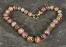 Collier – fermoir 585 or jaune, billes rondes multicolores (rhodonite ?) dégradées, L= env. 44 cm