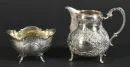Milk jug and sugar bowl – 800 silver, approx. 230 g, gilt interior, each on 4 curved feet, embossed rococo-style decorations, H= 5/9 cm