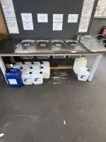1 table with 4 stainless steel containers for cleaning