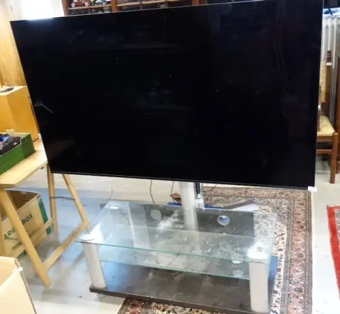 1 grote televisie en 1 glazen tv-tafel