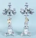 Paire de bougeoirs – porcelaine, peint à la main, riche décor avec fleurs en relief, base sur 3 pieds courbés, tiges figuratives avec...