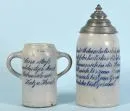 Bierhumpen, 2 Stück – Steinzeug, blau glasierte Trinksprüche, 1 mit Doppelhenkeln, 1 mit verziertem Zinndeckel und gravierter Widmung für…