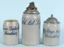 Chopes à bière, 3 pièces – chopes de cantine – grès, chacune avec désignation de régiment émaillée bleu, 2 avec couvercles en étain, 1 avec fusée d'obus montée, H= 13-23 cm, vers 1900, 2 avec fêlure sur la paroi