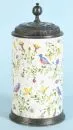Cylindrical jug – Faience, beige glaze, hand-painted with bird and floral decor, base ring and decorated pewter lid, H= 25 cm,...