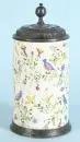 Chope cylindrique – Faïence, glaçure beige, peinte à la main avec décor d'oiseaux et de fleurs, anneau de base et couvercle en étain décoré, H= 25 cm,...