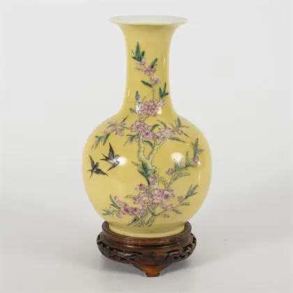Vase jaune avec fleurs roses, sur socle