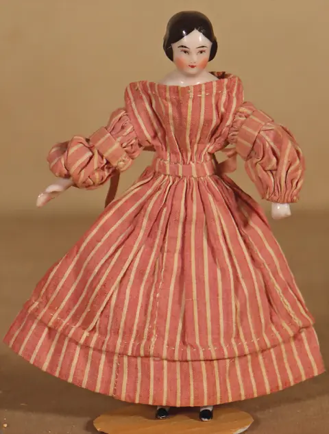 Rare petite poupée tête d'épaule en porcelaine avec cheveux noirs modelés en raie au milieu