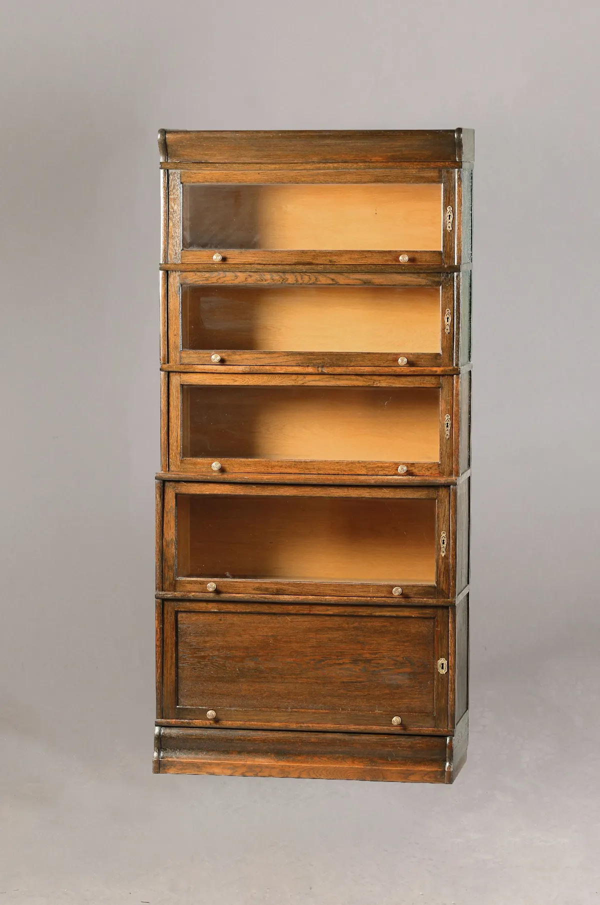 Bookcase, circa 1920, dark stained oak, composed of 5 elements, each