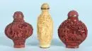 Snuffbottles, 3 pièces – 2x laque rouge, 1x beige, motifs paysagers richement sculptés avec personnages, corps balustre, chacune avec marque au fond, H=…