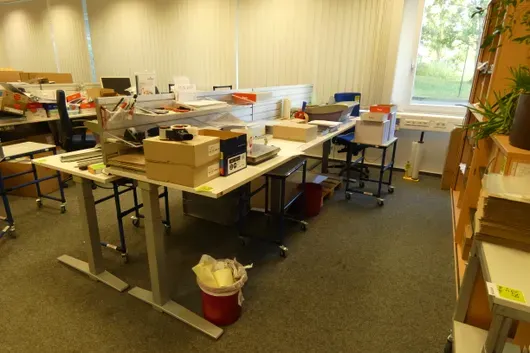 Electrically height-adjustable desk with back panel, without contents