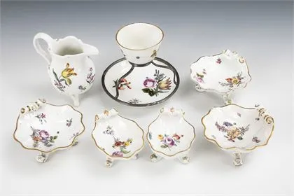 7 porcelaines baroques : 5 coupelles coquillage, pot à lait et tasse avec soucoupe et monture en argent. Meissen