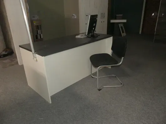 Tisch mit Besucherstuhl und Technik