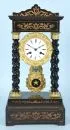 Portal clock – wood, brown stained and partly ebonised, decorated brass appliqués, 4 turned columns, enamel dial, 19th c.
