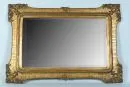 Spiegel – Holz/Gussmasse, bronzefarben gefasst, geschwungener Rahmen mit verzierten Ecken, Spiegelglas mit Facettenschliff, 106…