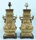 Pair of table lamps – cast brass, richly relief-decorated, wooden base, baluster body with 2 drop handles, 1 socket, H= 58 cm