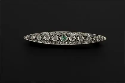 Brosche im Art déco-Stil mit Diamantsplittern und einem grünen Farbstein, wohl Smaragd