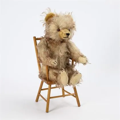Teddybär mit gespitztem Mohairfell, auf Stühlchen. Hermann, Hirschaid