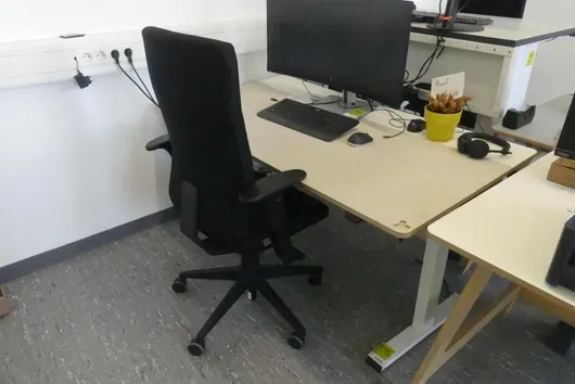 Electrically height-adjustable desk with office chair, without contents