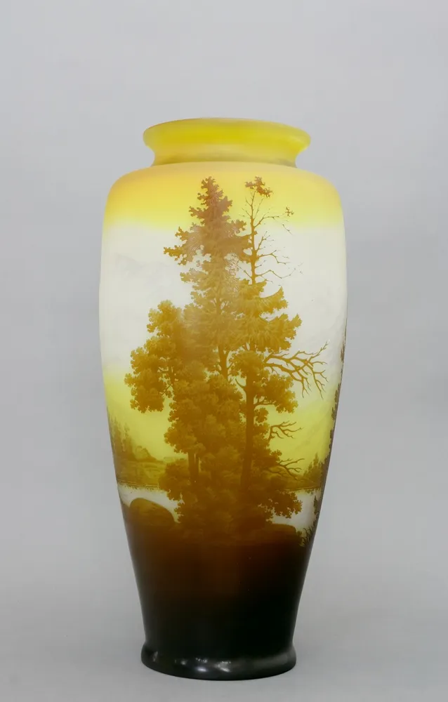 Vase, Emile Gallé, Nancy, Frankreich, um 1905 Milchig weißes Glas, tlw. leicht gelblich mit dem Dekor einer Berglandschaft und hohen Bäumen