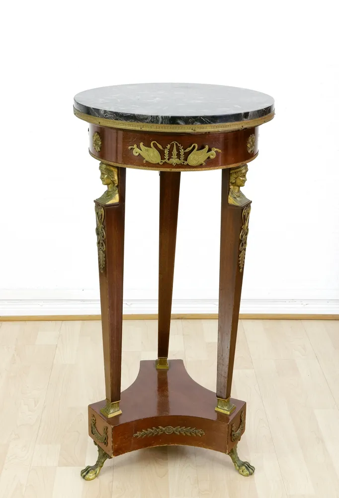 Guéridon or side table, Empire style, 19th c. Mahogany, with fine gilt bronze mounts, round marble top, surrounded by…