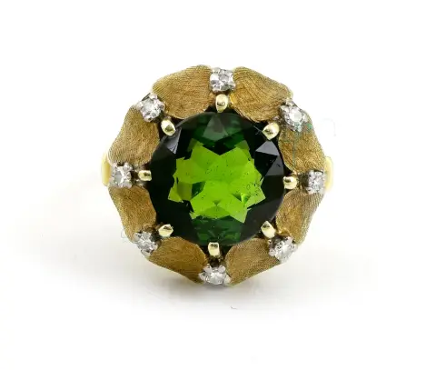 Bague, or gris 585 avec tourmaline verte et 8 brillants 0,16 ct. Taille 50/51, poids brut 6,95 g. Avec facture d'achat du 7. 4. 1964.
