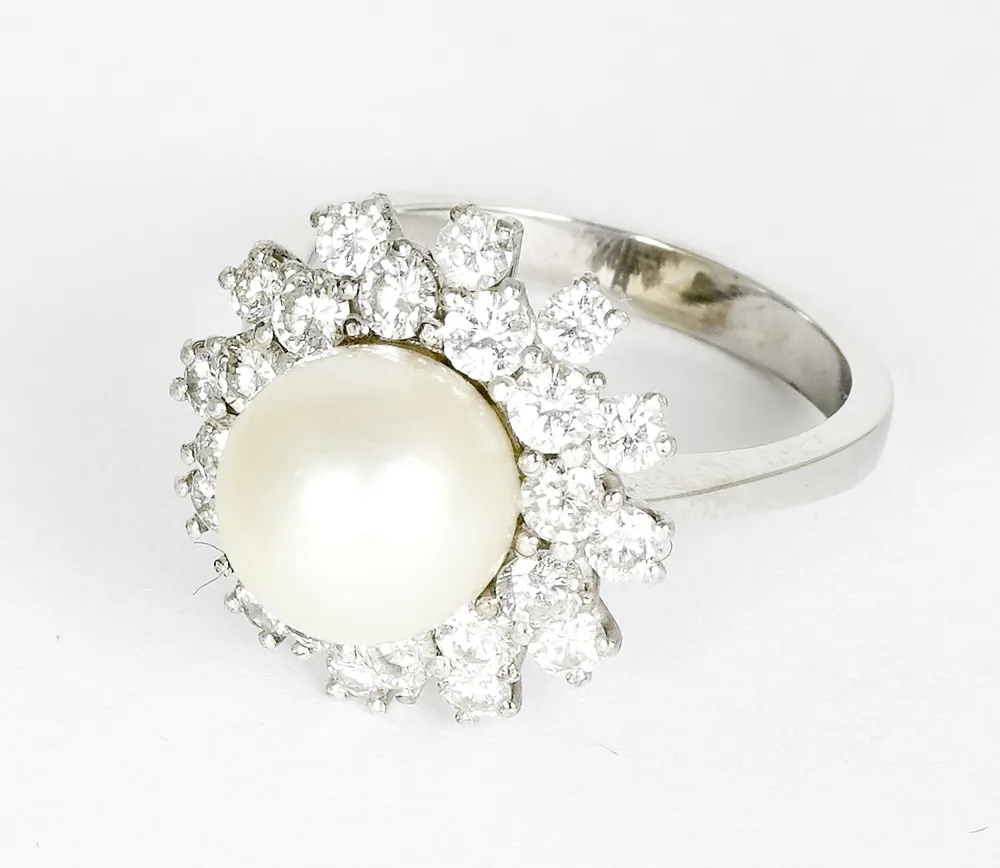 Bague, or gris 750 avec grande perle blanche centrale D. : env. 9,5 mm, entourée d'un double cercle de 24 petits diamants taillés