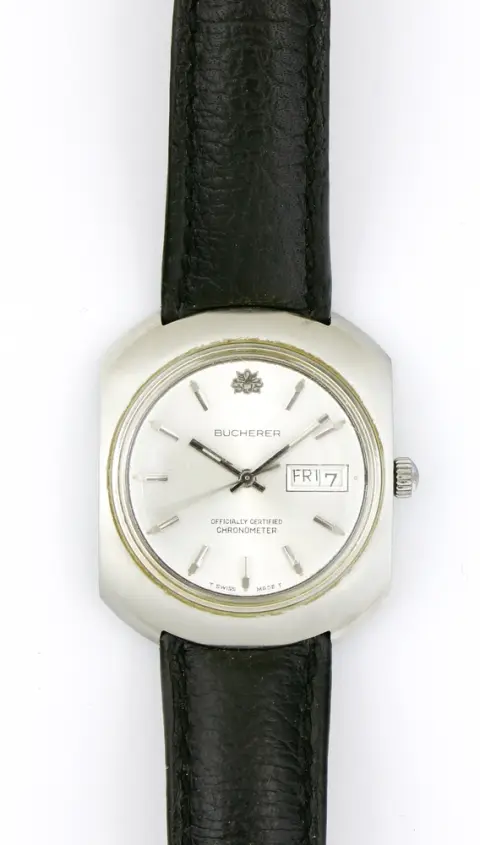 Montre, bracelet, Bucherer, acier, boîtier arrondi, diamètre env. 35 mm, cadran argenté avec index, jour et date, inscription "Officially Certified Chronometer". Bracelet en cuir. Fonctionne, durabilité non testée. Bucherer vendu à Rolex en 2023. Partenariat depuis 1924.