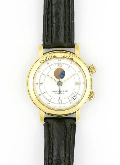 Montre, bracelet, Harwood & Schild, Montre Reveil, vers 1990, boîtier rond, diamètre env. 38 mm. Cadran blanc avec chiffres romains. Doré. Automatique. Réveil, phase de lune, date, chronographe. Édition limitée numéro 736 sur 1999. Bracelet en cuir. Fonctionne, durabilité non testée. Verre avec traces d'usure.