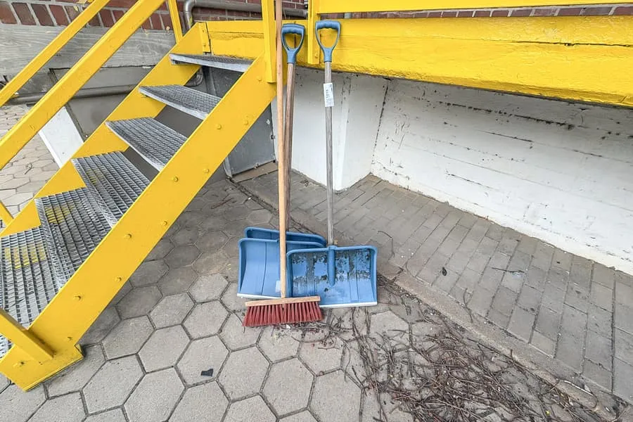 3 snow shovels and brooms
